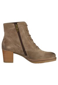 Botte cheville en daim beige avec talon empilé, fermeture éclair latérale et détails à lacets sur le devant, conçue pour une utilisation décontractée ou habillée.
