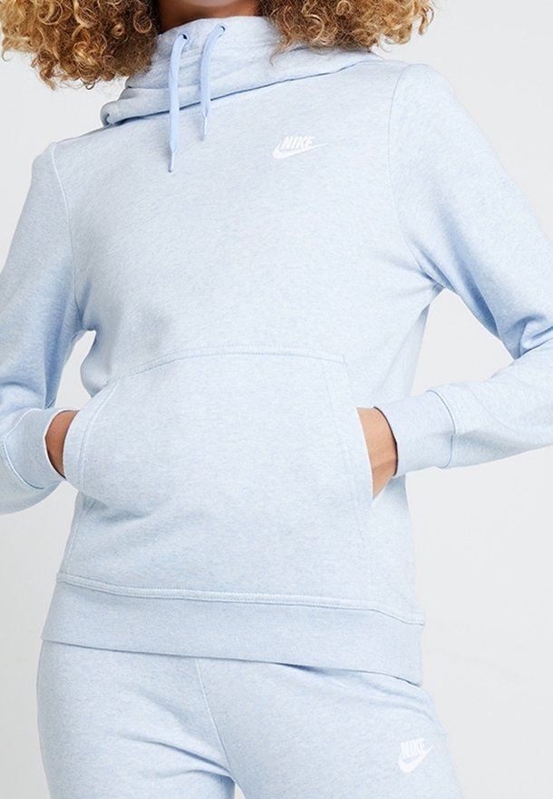 Ljusblå fleecehoodie med kengurufickor, dragsko på huvan och vit Nike-logotyp på bröstet. Mjuk textur, avslappnad passform.