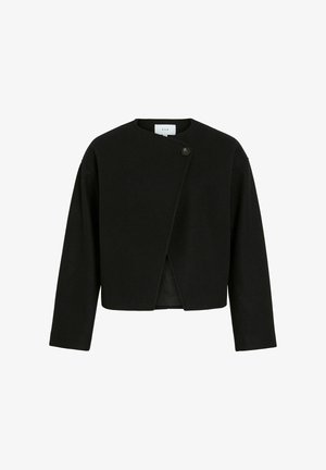 Veste noire à manches longues et cropped avec un panneau arrière asymétrique se chevauchant, fixé par un seul bouton près du col.