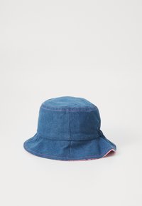 Chapéu de pescador em denim azul com costuras rosas. Apresenta uma aba larga e flexível e um tecido texturizado, adequado para vestuário casual.