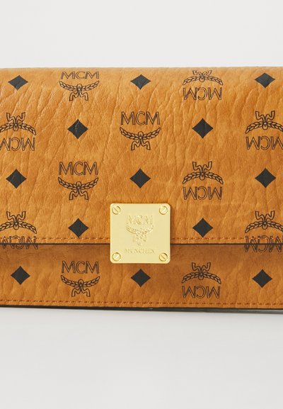 Käytännöllinen ruskea nahkakukkaro, jossa on kohokuvioitu logo ja timanttikuvioita, sekä kultasävyinen metallilaatta etupuolella. Raskasti tekstuuri.
