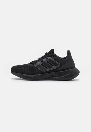 Schwarzer Sportschuh mit Mesh-Obermaterial, gepolsterter Sohle und schwarzem Drei-Streifen-Logo seitlich, im Seitenprofil auf weißem Hintergrund gezeigt.