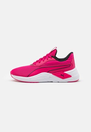 Bright pink athletic sneaker with white sole, black inner lining, lace-up design, and Puma logo on the side, shown in profile.