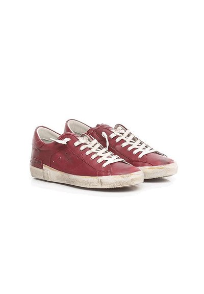 Baskets en cuir rouge avec lacets blancs, surface texturée, semelles légèrement usées et détail de logo subtil sur le côté. Design basique classique.