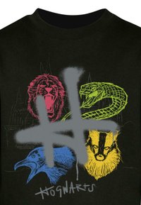 Maglietta nera con illustrazioni colorate di un leone, un serpente, un corvo e un tasso, con una sovrapposizione grafica di hashtag grigia e il testo "Hogwarts".