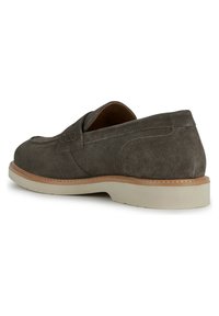 Chaussure en daim gris à enfiler avec un bout arrondi, des coutures apparentes et une semelle en caoutchouc claire. Design minimaliste avec une texture lisse.