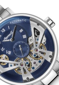 Automatisch horloge met een blauwe textuur-dial, zilveren accenten, skeletontwerp en zichtbare gouden tandwielen; heeft Romeinse cijfers en een datum subdial.