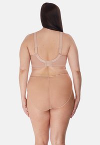 Reggiseno wireless beige con spalline regolabili, mutandine in rete testurizzata, design senza cuciture e chiusura con ganci sul retro.