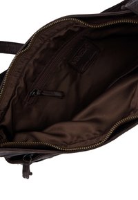 Innenraum einer braunen Lederhandtasche mit glattem Stofffutter, einem Reißverschlussfach und einem Logopatch. Reißverschluss mit Metallbeschlägen.