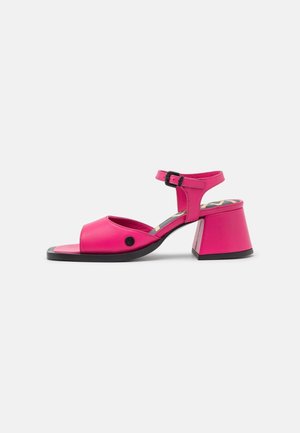 Roze leren sandalen met hakken, open tenen, verstelbare enkelband en een brede blokhak. Vlakke textuur met een contrasterende zwarte zool.