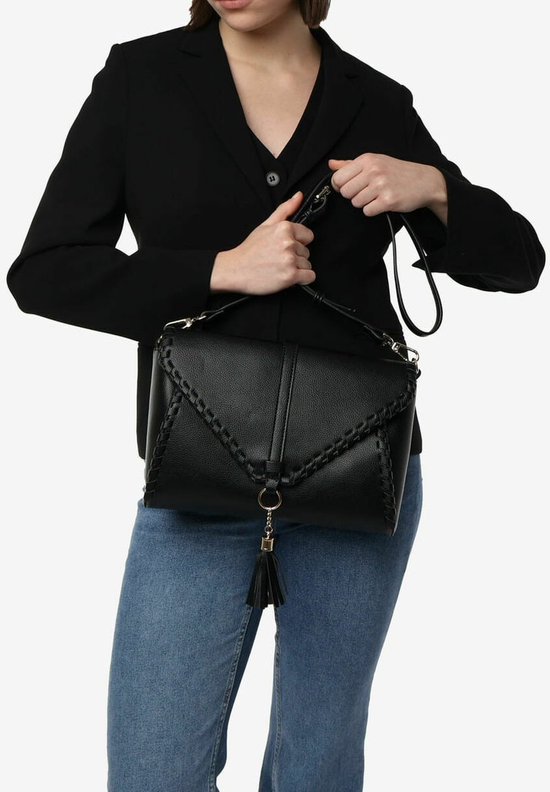 Bolso de mano de cuero negro con detalle trenzado, cierre de solapa y correa desmontable. Presenta un adorno de borlas y un diseño estructurado.