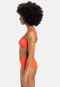 Oranžový rebrovaný bikini set s vybaveným podprsenkovým topom a vysokými nohavičkami, obe s nastaviteľnými ramienkami a textúrovaným povrchom.