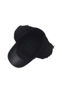Cappello nero con visiera lucida e orecchie in pelliccia, caratterizzato da un interno liscio e una forma strutturata.