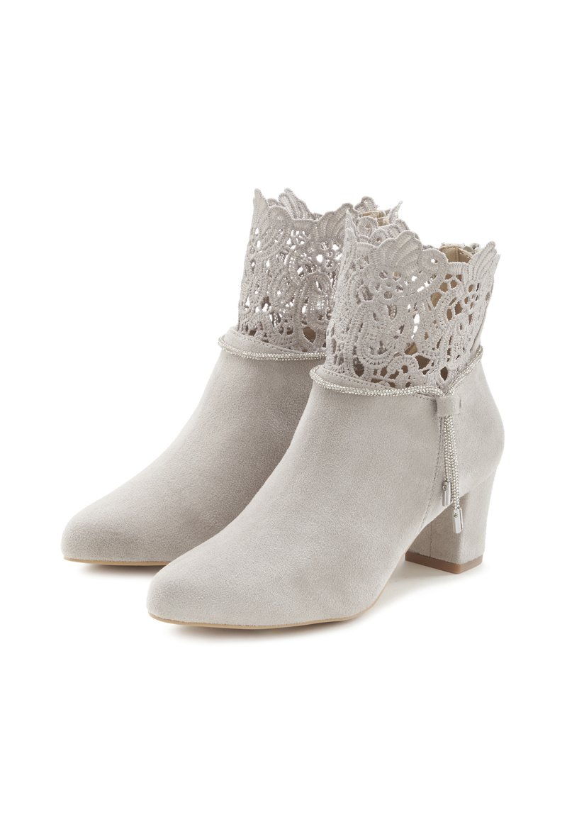 Botines de ante gris con una parte superior decorativa similar a un encaje, pequeño tacón cuadrado y detalle de cremallera, que presentan una textura suave y punta afilada.