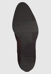 Schwarze Gummisohle mit einem strukturierten Muster, das geometrische Formen und hervorgehobene Elemente für besseren Halt aufweist. Mit Marken- und Größenangaben gekennzeichnet.