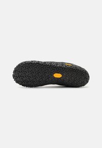 Black Vibram outsole featuring a textured pattern with a prominent yellow logo, designed for traction and durability.
