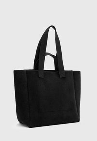 Sac fourre-tout noir en feutre avec deux poignées en tissu robustes, de forme rectangulaire et une poche avant avec une finition texturée.