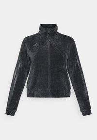 Crna flis jakna s visokim ovratnikom, zatvaranjem na zip i bočnim trakama. Ima teksturiranu tkaninu i Adidas logo na gornjem lijevom dijelu.