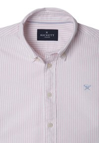 Světle růžová a bílá pruhovaná košile s knoflíky a límečkem, s malým modrým logem na hrudi. Bavlněná látka.