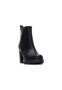 Stivale alla caviglia nero in pelle, con chiusura a zip, tacco alto e grosso, e suola texturizzata. Superficie liscia con design minimalista.