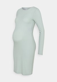 Långärmad gravidklänning i ljusgrön ribbad tyg. Åtsittande design, knälång, rund halsringning, mjukt material med lätt stretch.
