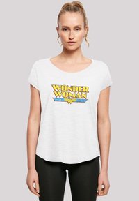 Maglietta bianca a maniche corte con un vivace design grafico "Wonder Woman" giallo e blu sul davanti. Vestibilità casual con scollatura rotonda.