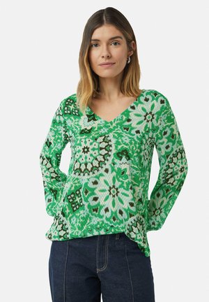 Groen patroon lange mouw top met een V-hals, met bloem- en geometrische ontwerpen in tinten groen, crème en bruin.