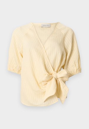 Ελαφρώς κίτρινο μπλουζάκι με υφή wrap, με κοντά φουσκωτά μανίκια και μεγάλο φιόγκο στη μέση, με ετικέτα Anna Field.