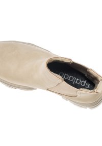 Zapato slip-on beige con parte superior de ante, paneles laterales elásticos y plantilla acolchada. Presenta una suela de goma texturizada para mayor agarre.