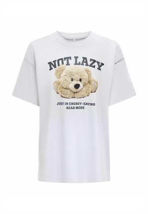 Bela bomba majica z oversized krojem, ki vsebuje potiskan grafiko teddy medvedka in napis: "NISEM LEN, SAMO SEM V NAČINU VARČEVANJA Z ENERGIJO MEDVEDKA."