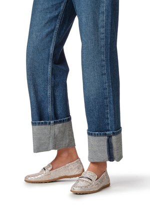 Vaaleat metallinhohtoiset loafersit, joissa on teksturoitu leopardi-kuvio. Yhdistetty tummiin farkkuihin, joiden lahkeet on kääritty ja joissa on vaaleansininen helmassa. Kengissä on tasainen pohja.