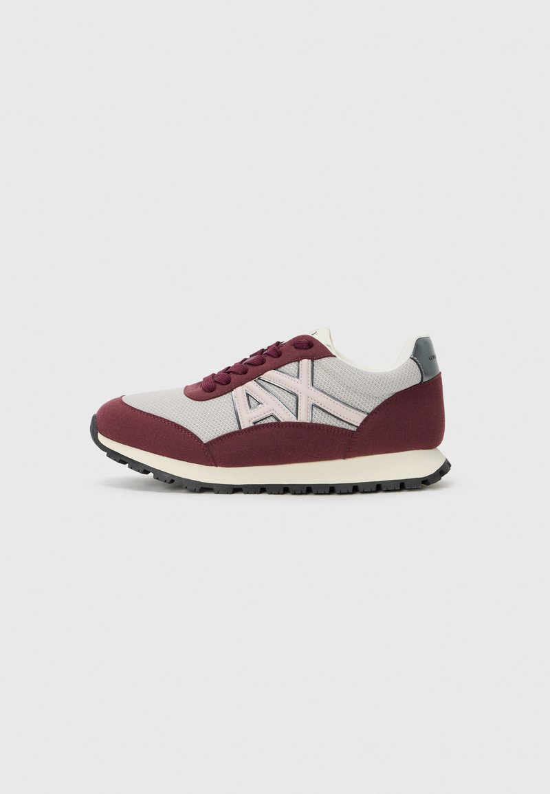 Baskets en mesh rouge et gris avec un bout arrondi, un design à lacets, des accents contrastés, et une semelle en caoutchouc noir avec un profil texturé.