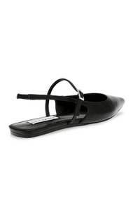 Scarpa flat slingback in pelle nera con punta affusolata, lati scoperti e una sottile cinghia alla caviglia con una fibbia decorativa. Suola piatta.