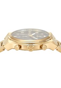 Gold-colored stainless steel watch with a black dial, featuring large numerals, a rotating bezel, and distinctive crown and pushers.