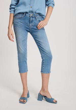 Light blue denim capri jeans featuring a high waist, five-pocket design, and frayed hem, paired with matching square-toed high-heeled mules.