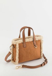 Bolso de ante marrón con ribete de pelo sintético crema, asas superiores y una correa de hombro desmontable. Cuenta con herrajes dorados y detalles de costura.