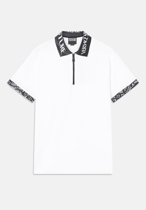 White polo shirt with a black zip and collar. Features black trim at sleeves with repeating text pattern. Smooth texture, sporty design.