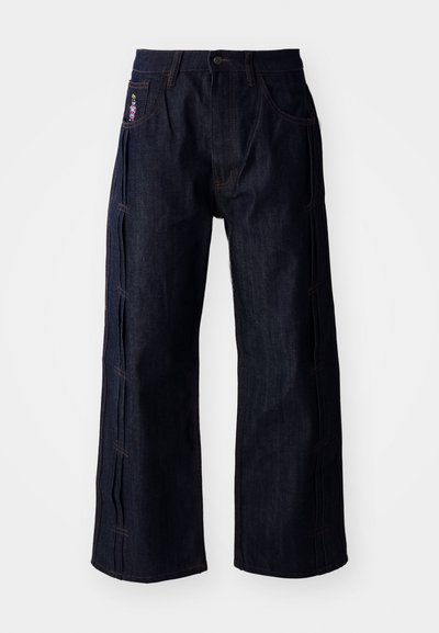 Dark blue denim jeans with a wide-leg cut, featuring contrasting stitching and embroidered detail on the front pocket. Smooth texture.