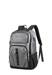 Sac à dos en tissu gris avec plusieurs compartiments, accents noirs, bretelles rembourrées et finition texturée avec des détails réfléchissants.