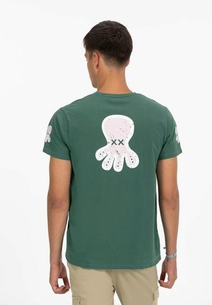 Camiseta de algodón verde con un gran gráfico de pulpo blanco en la espalda y pequeños estampados de pulpos en ambas mangas.