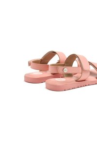 Sandalias rosas con dos correas ajustables, textura suave, suela plana y un logo redondo en la plantilla. Diseñadas para la comodidad y facilidad de uso.