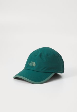 Teal cap with a curved brim, made of water-resistant fabric. Features a logo on the front and the word "DRYVENT" on the side. Lightweight design.