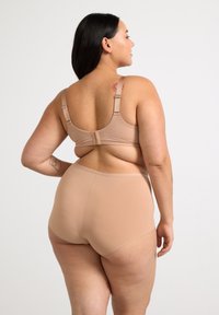 Nude breathable bra with adjustable straps and hook closure, paired with matching high-waisted briefs, highlighting smooth texture and seamless design.