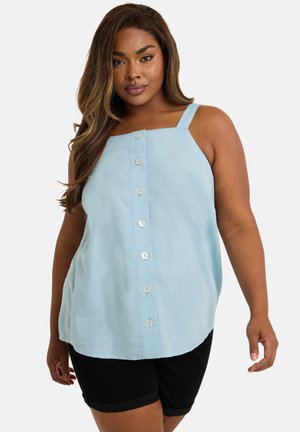 Blouse sans manches bleu clair, à coupe droite et décontractée, avec un devant à boutons et des bretelles carrées. Associée à un short noir.