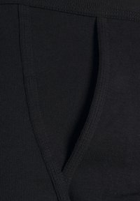 Black ribbed fabric with a smooth texture, featuring a visible seam and V-shaped design element. Material appears soft and stretchy.