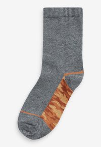 Grau gestrickte Socke mit gerippter Textur, die ein oranges Camouflage-Muster im unteren Bereich aufweist. Glattes Material und verstärkter Zehenbereich.