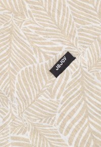 Beige stof met een wit loofpatroon, voorzien van een zwart label met de tekst "J&JOY". Zachte textuur, verfijnde details in het ontwerp.