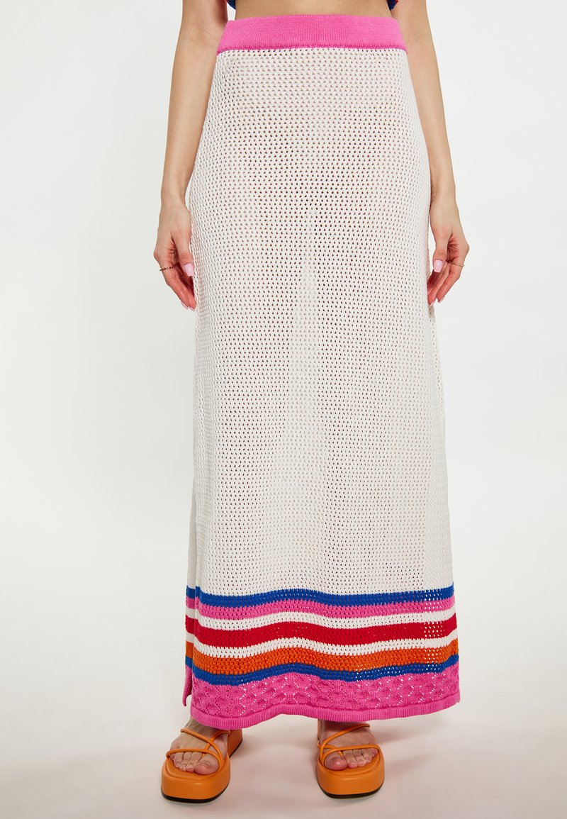 Witte gebreide maxi-rok met een roze tailleband, met horizontale strepen in blauw, rood, oranje en roze aan de zoom.