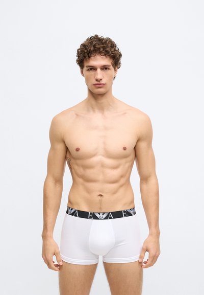 Białe bokserki z bawełny z czarnym elastycznym pasem w talii ozdobionym logo. Gładka faktura i dopasowany krój.