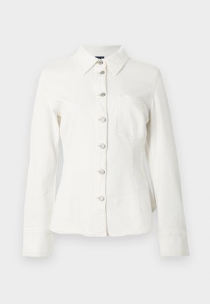 Chemise en denim blanc avec col, manches longues et fermeture à boutons sur le devant. Comprend une poche poitrine unique et des boutons argentés en guise d'accents.